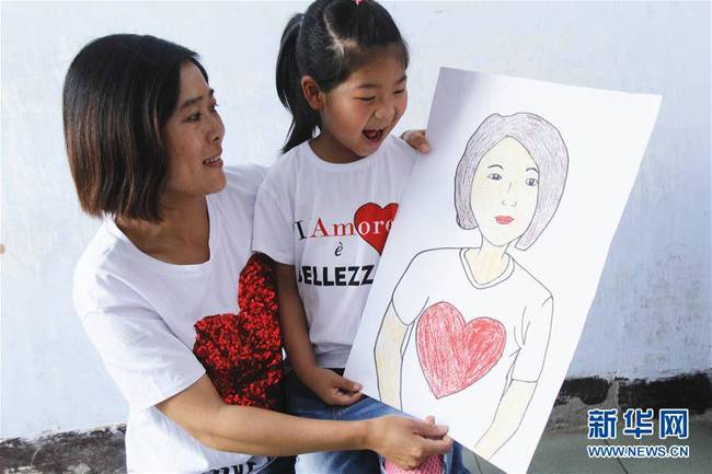 5月10日，在河北唐山市豐潤(rùn)區(qū)迎賓路幼兒園開(kāi)展的“媽媽?zhuān)覑?ài)你”主題活動(dòng)中，陳悅寧小朋友將自己的繪畫(huà)作品送給媽媽作為節(jié)日禮物。 新華社發(fā)（朱大勇 攝）