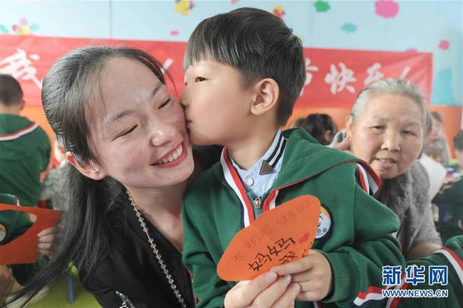 5月10日，在湖北省襄陽(yáng)市一家幼兒園舉辦的母親節(jié)主題活動(dòng)中，一名小朋友將自己制作的賀卡獻(xiàn)給媽媽。 新華社發(fā)（安富斌 攝）